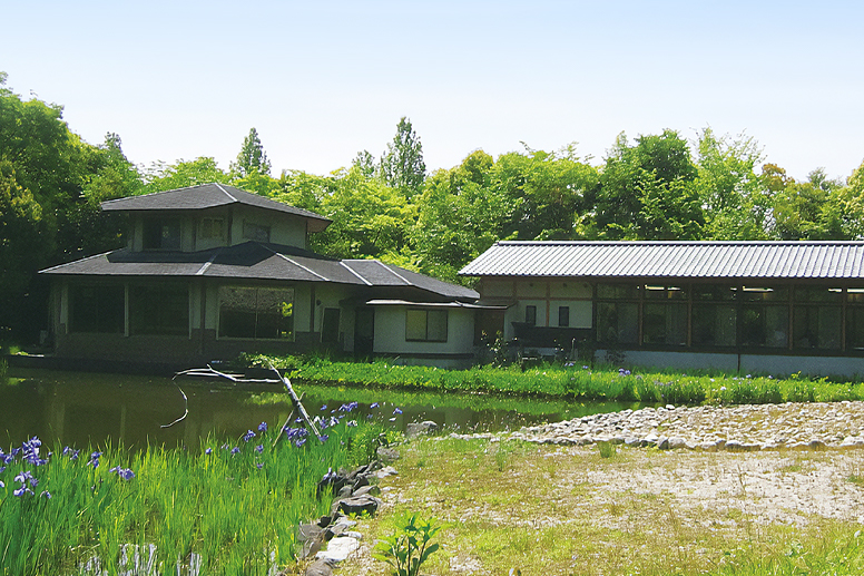 A bird sanctuary building standing beside a pond