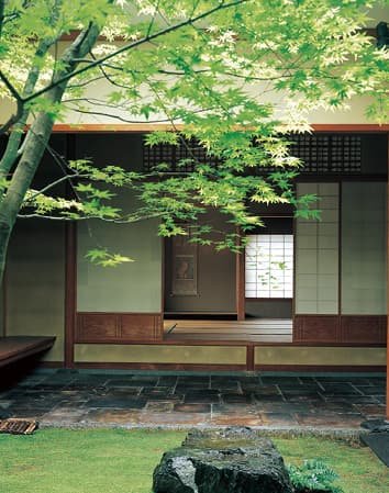 A courtyard and zashiki sitting room seen through the trees