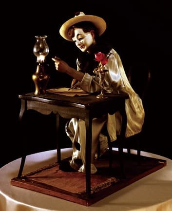 A music box doll seated at a desk