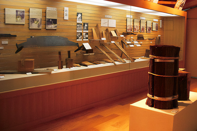 A display case containing wooden tubs and tools