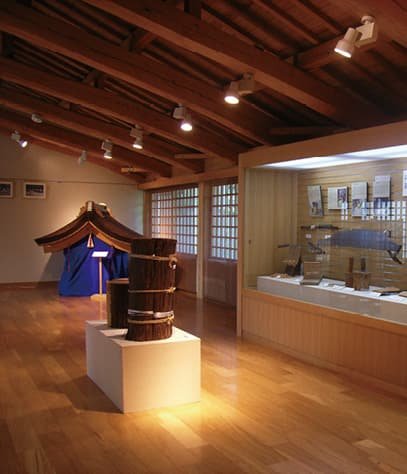 An exhibition room with wooden tubs and glass cases