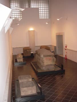 A display room lined with stone sarcophagi