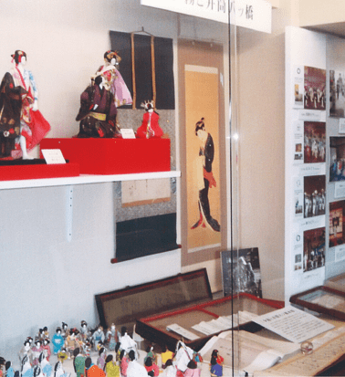 A display case featuring dolls and materials