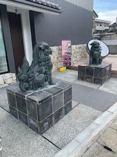A komainu guardian statue standing in front of the entrance