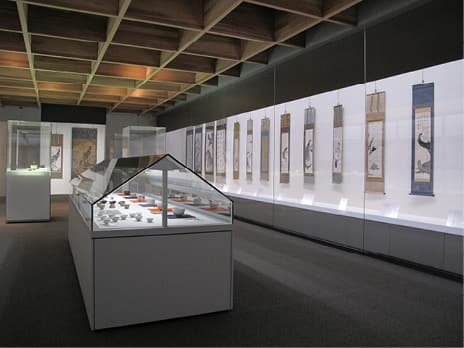 An exhibition room displaying hanging scrolls