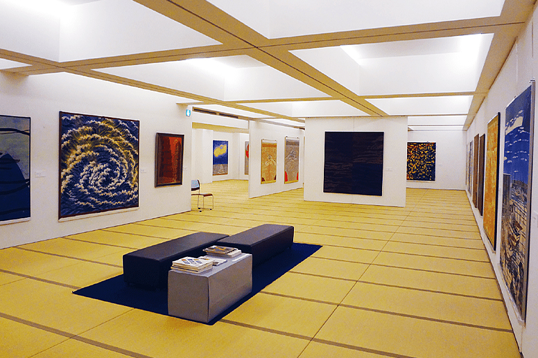 A tatami-floored exhibition room displaying artworks