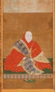 A hanging scroll depicting a figure in red attire.