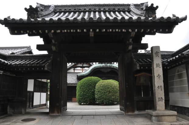 A stone monument and temple gate standing before the entrance