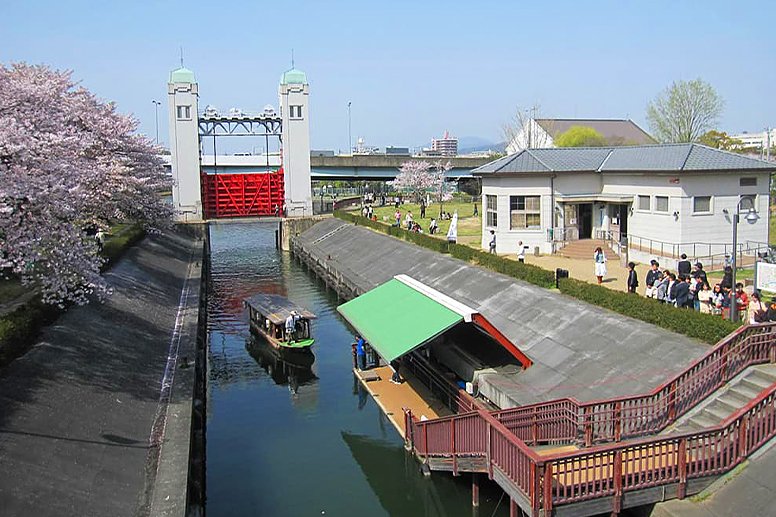 A scene of cherry trees and a canal lock