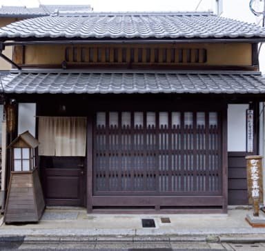 The exterior of a machiya townhouse with a lattice door