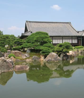 A building and garden reflected in a pond