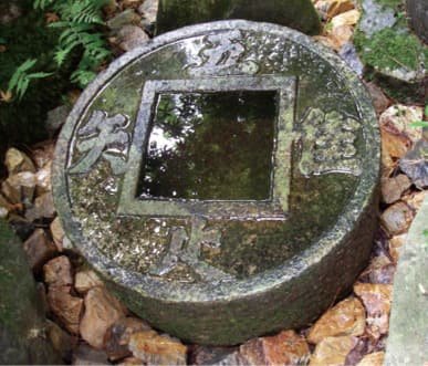 A stone tsukubai basin with a square opening
