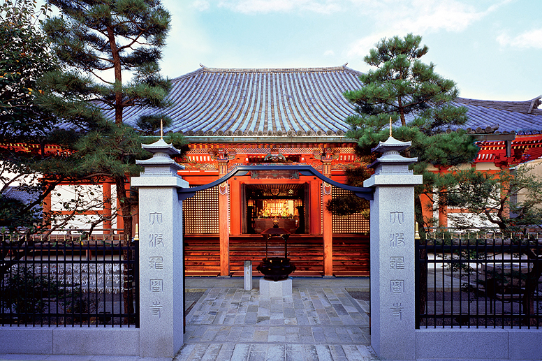 The front of a temple beyond a stone pillar