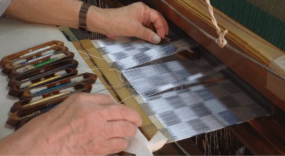 手元で織物を織る作業